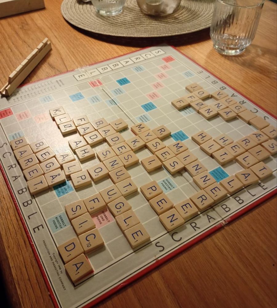 Et påbegynt Scrabble-spill på trebordet